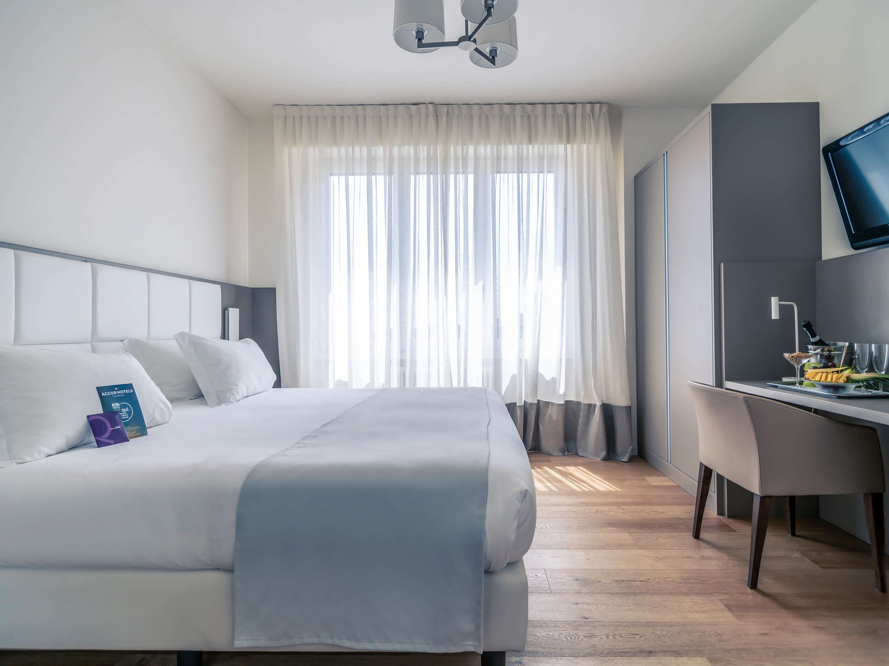 Janela de hotel aberta para os telhados da cidade