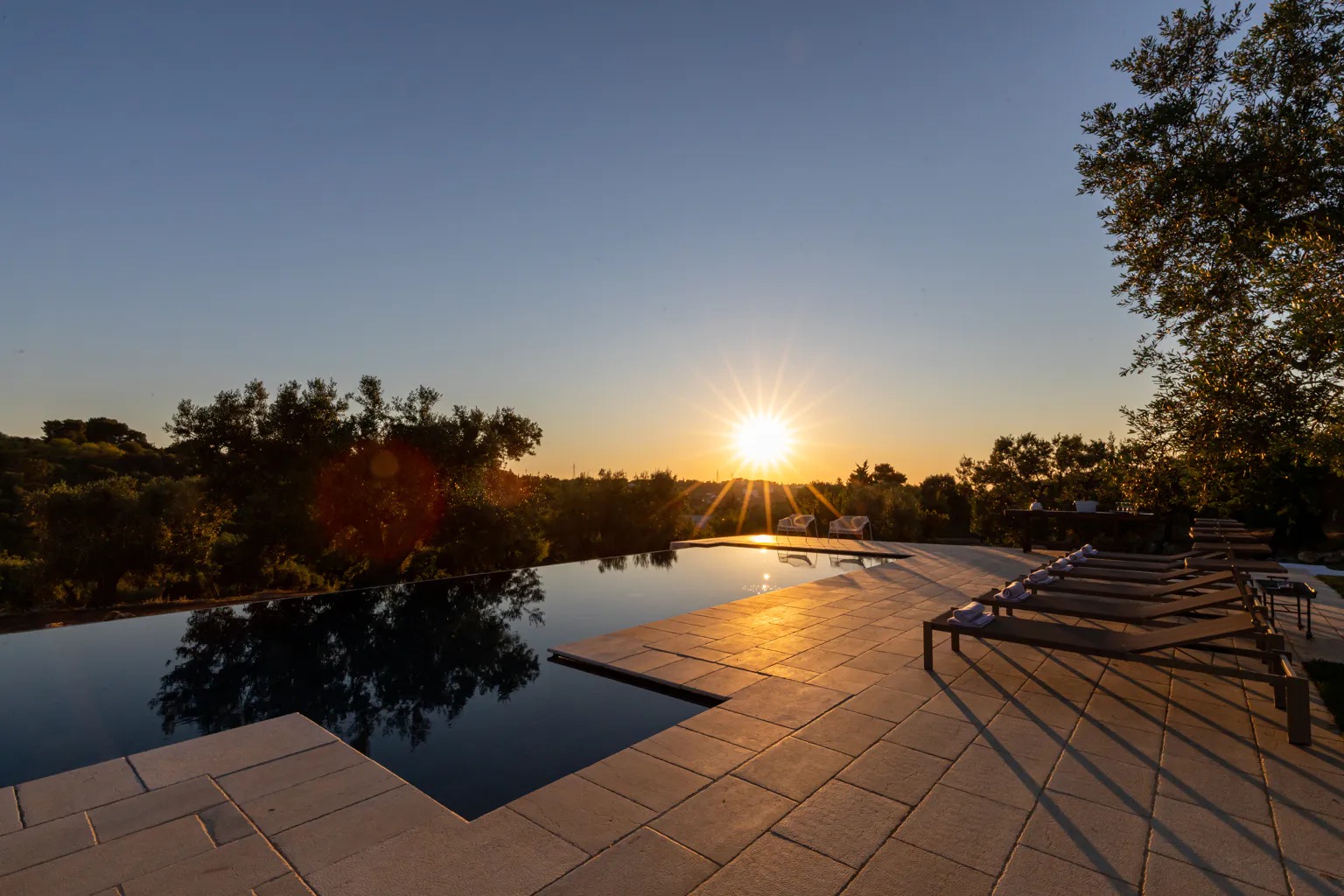 Casal caminhando por uma trilha aberta com vista para o vale ao entardecer