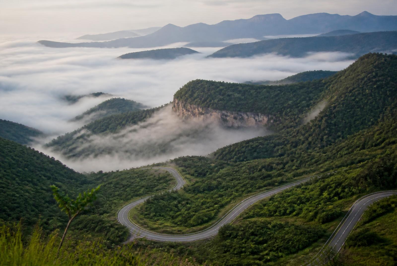 Serra com neblina e estrada sinuosa